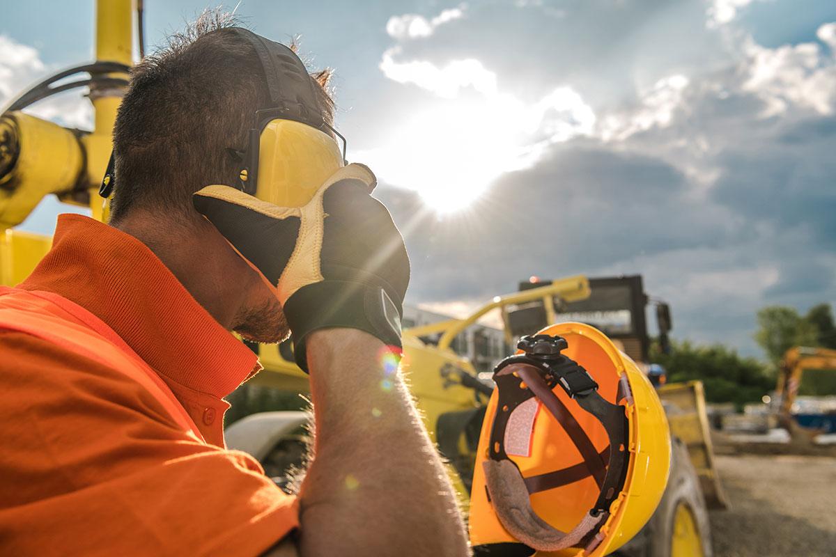 A San Juan College student putting on a hard hat while standing on a construction site