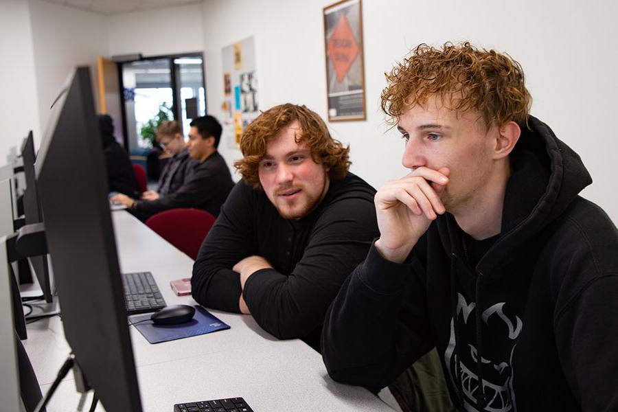 Two 太阳集团娱乐场登陆网站 students sit in front of a computer